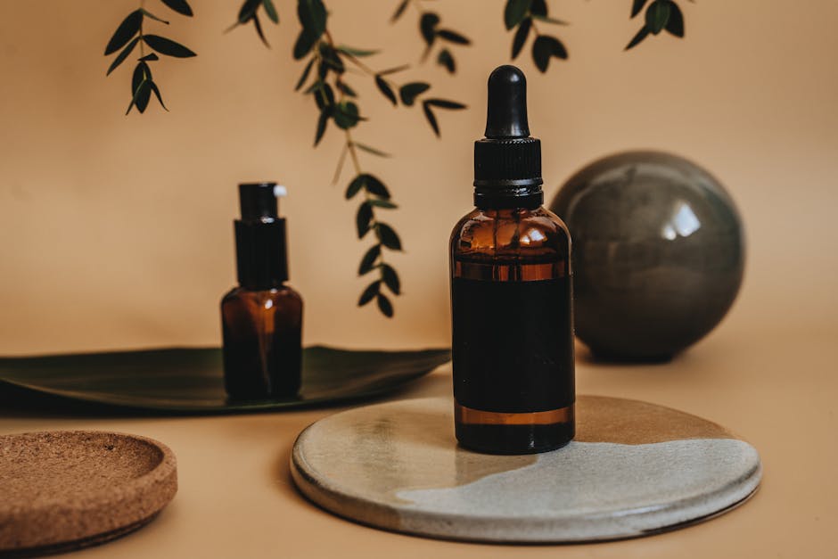 Elegant arrangement of amber dropper bottles with green leaves and earthy textures in a minimalist style.