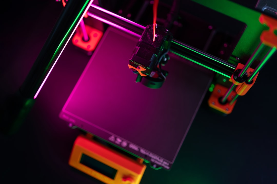 A 3D printer illuminated with colorful lights.