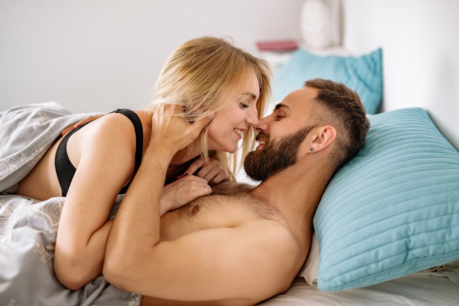 Intimate moment of a couple embracing and smiling warmly in bed.