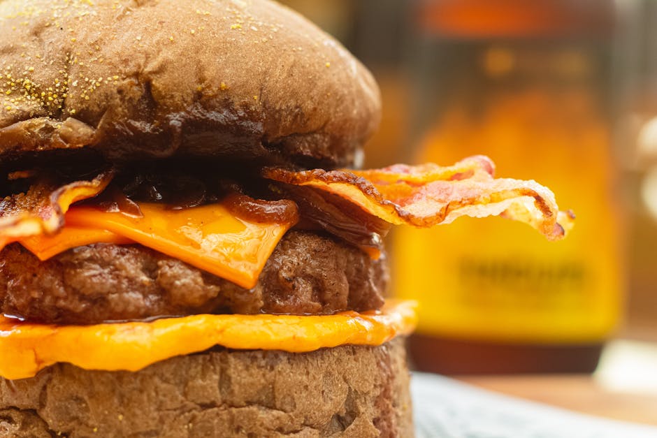 Mouthwatering close-up of a bacon cheeseburger with melted cheese and crispy bacon.