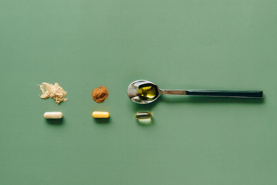 Top view of various supplements and powders on a green surface with a spoon.