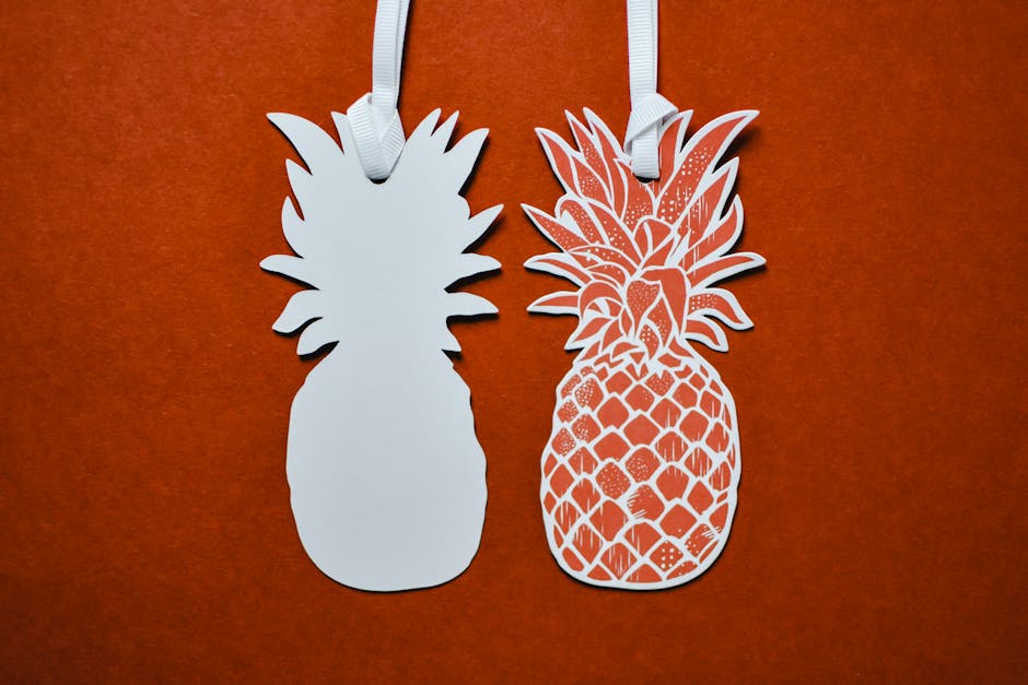 Creative paper pineapple silhouettes on a bold red background in a studio setup.