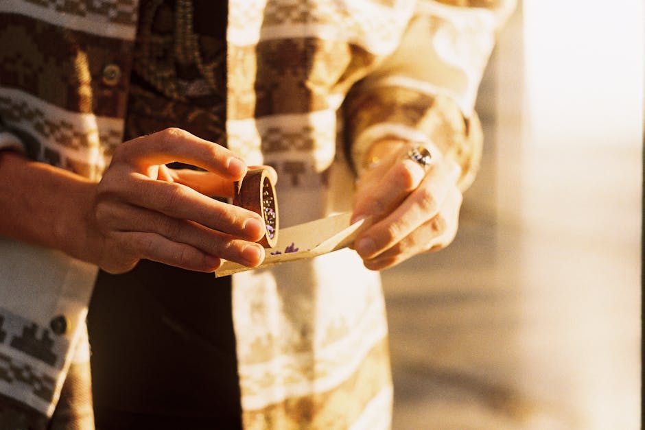 Close-up of hands holding an envelope and sealing ring in warm vintage light.