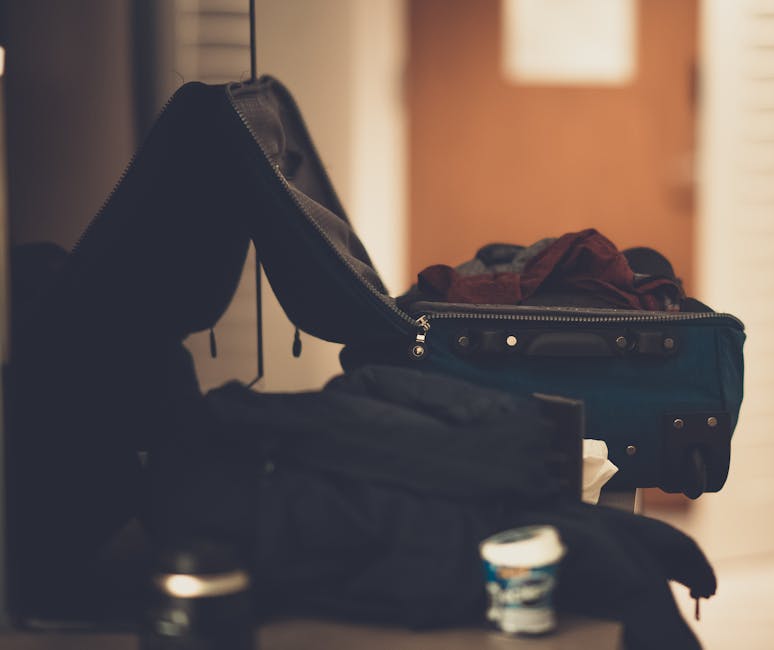 A warm-toned indoor image of an open suitcase with clothes, conveying travel readiness.