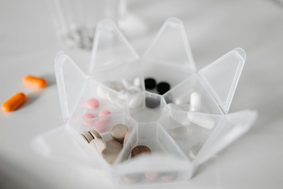 Close-up of various pills in a weekly pill organizer, healthcare concept.