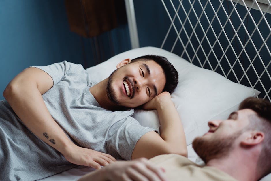 A loving and happy interracial gay couple sharing a moment of joy and relaxation in bed.