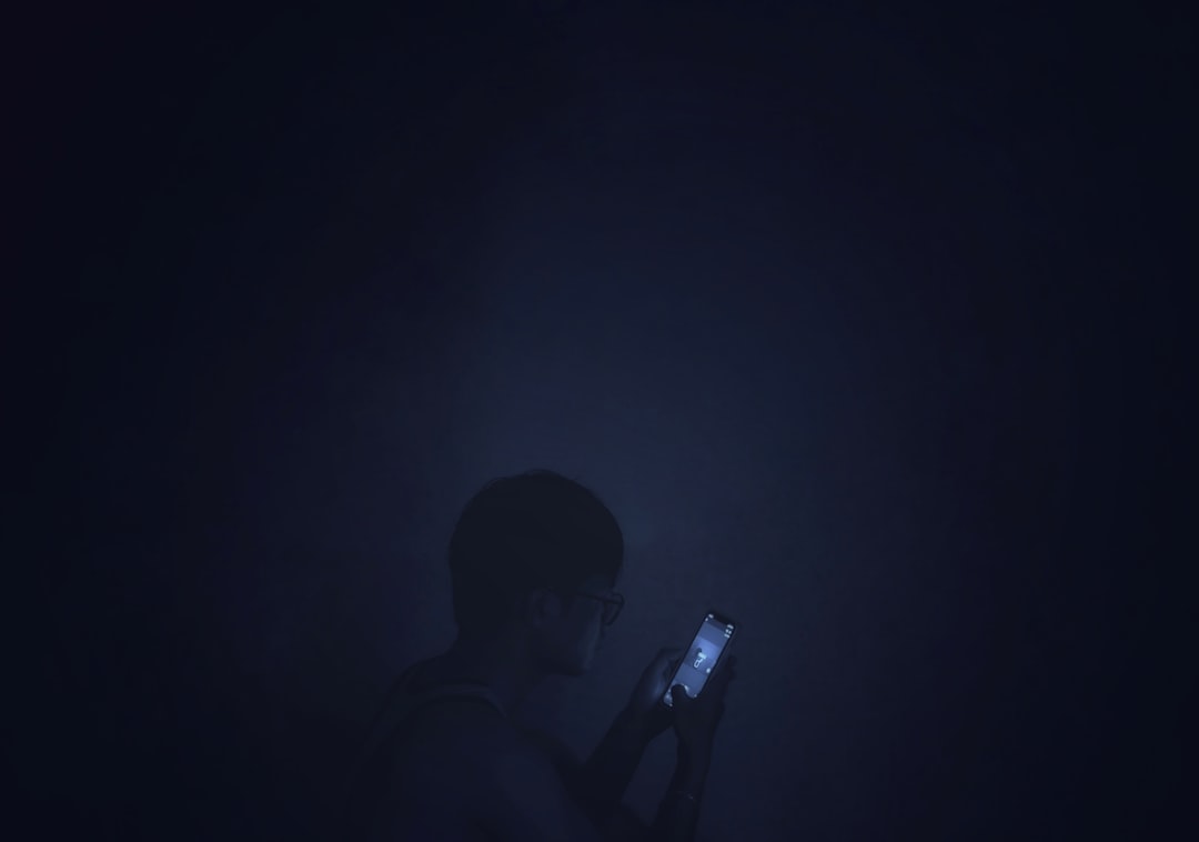 a man holding a cell phone in the dark