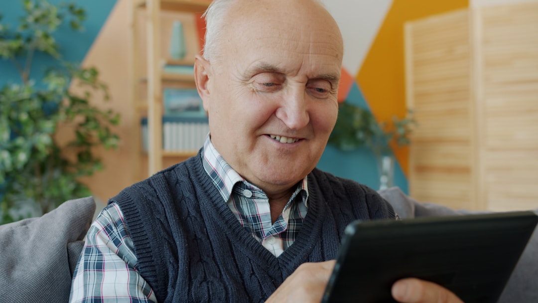 Smiling senior man using a tablet computer at home.