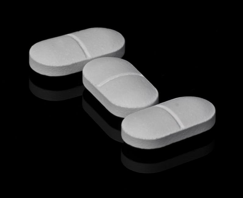 Three white tablets placed on a black reflective surface, highlighting pharmaceutical theme.