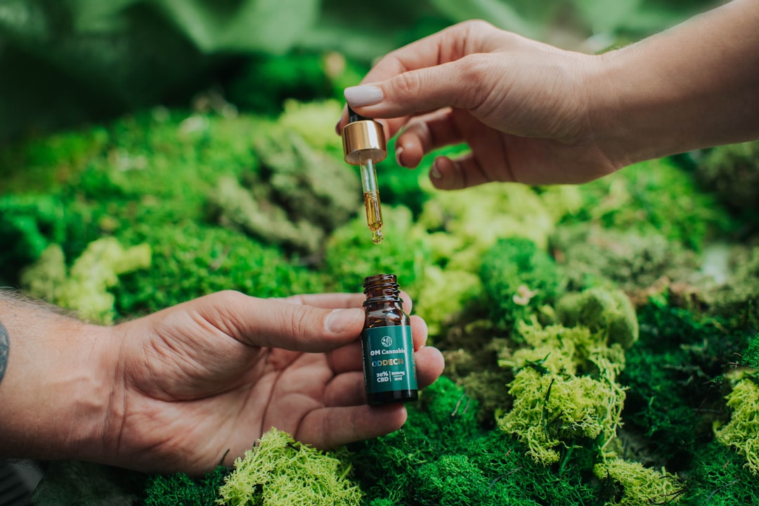 a person holding a bottle of essential oil in their hand