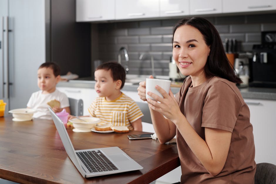 Family enjoying breakfast in a modern kitchen. Woman holding coffee and smiling.