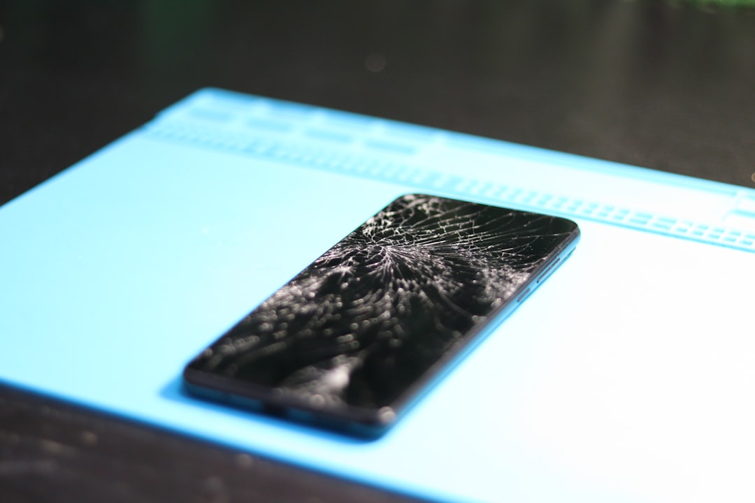 Cracked smartphone screen on a repair mat.